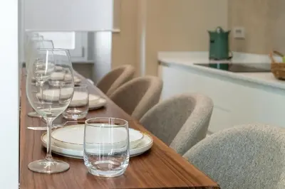a wooden table with wine glasses on top of it at Skylife Minimalist Boutique Apartment in Rome