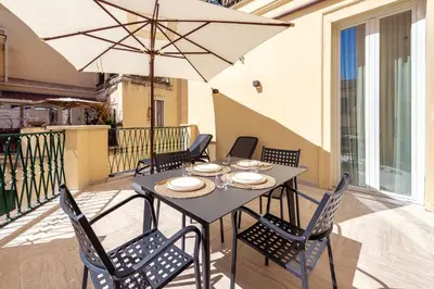 a table with chairs and an umbrella on a balcony at Skylife Minimalist Boutique Apartment in Rome
