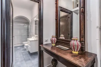 a bathroom with a mirror and two vases on a table at Casa Belle Arti in Rome