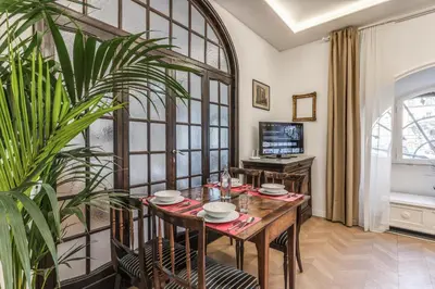 a dining room with a table and a plant at Casa Belle Arti in Rome