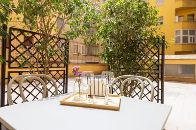 a white table with chairs and a vase with flowers on it at Casa Girasole in Rome