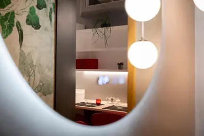 a mirror reflection of a kitchen with a table in a room at Spagna Suite Luxury Home - Trevi Fountain in Rome