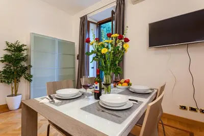 a dining room with a table with chairs and a television at Vatican Loris House in Rome