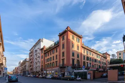 a tall brick building on a city street with cars at Vatican Loris House in Rome