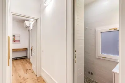 a hallway with white walls and a window and a door at Silent 2 Bdrm heart of Trastevere in Rome