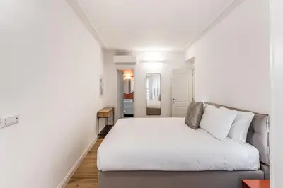 a white bedroom with a bed and a couch at Silent 2 Bdrm heart of Trastevere in Rome