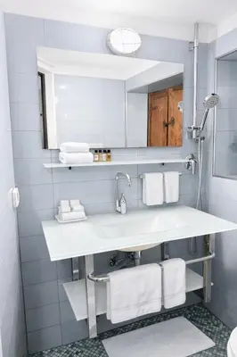 a bathroom with a sink and a mirror and towels at Piazza Navona Historic Escape in Rome