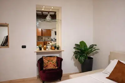 a living room with a chair and a bedroom at Piazza Navona Historic Escape in Rome