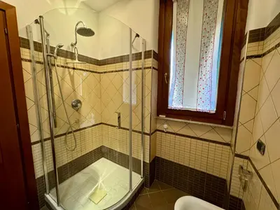 a bathroom with a glass shower and a toilet at Doria Boutique Apartment in Rome