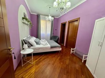 a bedroom with purple walls and a bed with a table at Doria Boutique Apartment in Rome
