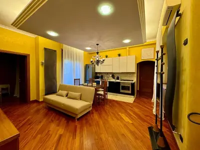a living room with a couch and a kitchen at Doria Boutique Apartment in Rome