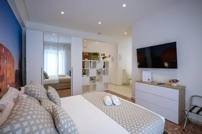 a bedroom with a large bed and a television at Luxury Suite-Metro Malatesta in Rome