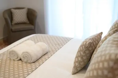 a bed with two rolled towels on top of it at Luxury Suite-Metro Malatesta in Rome
