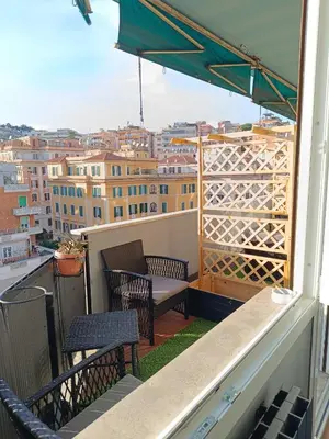 a balcony with two chairs and an umbrella at Trastevere Noir in Rome