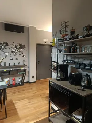 a room with a kitchen with a table and shelves at Trastevere Noir in Rome