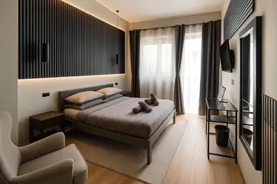 a bedroom with a bed and a chair at Trastevere Noir in Rome