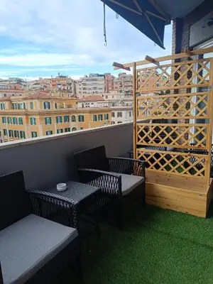 a balcony with chairs and tables and a view of a city at Trastevere Noir in Rome