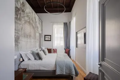 a bedroom with a bed and a painting on the wall at Luxury apartment in Trastevere San Calisto in Rome