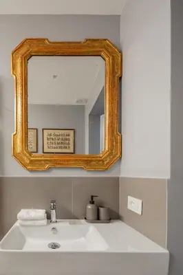 a bathroom with a mirror over a white sink at Luxury apartment in Trastevere San Calisto in Rome
