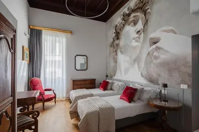 a hotel room with two beds and a painting on the wall at Luxury apartment in Trastevere San Calisto in Rome