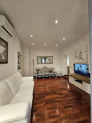 a living room with a white couch and a flat screen tv at A Casa di Luca in Rome