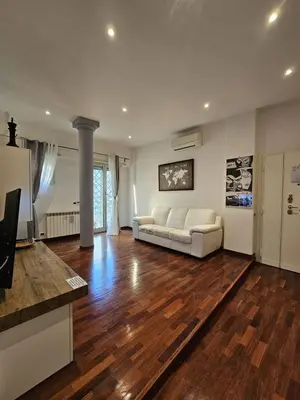 a living room with a white couch and wooden floors at A Casa di Luca in Rome