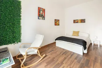 a bedroom with a bed and a chair and a plant at San Giovanni Living House in Rome
