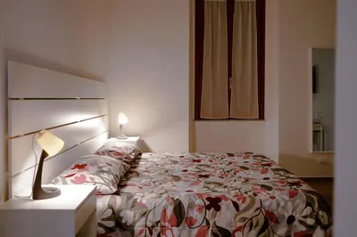 a bedroom with a bed and a lamp on a night stand at Vatican 23 Apartment in Rome