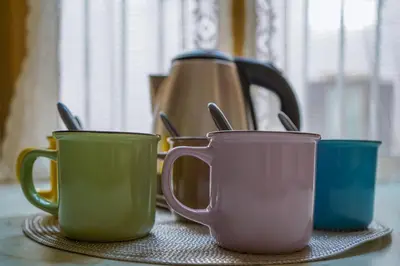 three coffee cups sitting on a table with a tea kettle at Vatican 23 Apartment in Rome