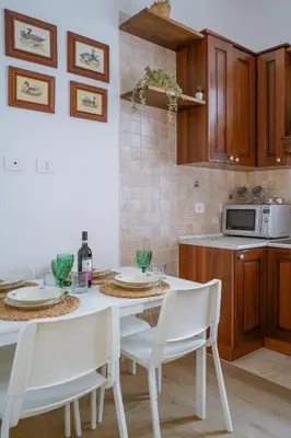 a kitchen with a white table and white chairs at Vatican 23 Apartment in Rome