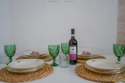 a table with plates and glasses and a bottle of wine at Vatican 23 Apartment in Rome