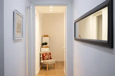 a hallway with a mirror and a chair next to a door at Maison Aurora in Rome