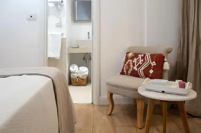 a bedroom with a chair with a tray on a table at Maison Aurora in Rome