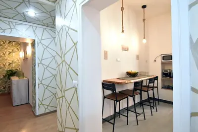 a kitchen with a counter and a bar with stools at Due passi dal cupolone - appartamento al centro in Rome