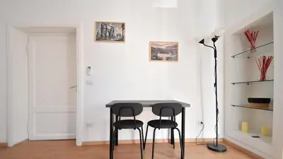 a table and two black stools in a room at Due passi dal cupolone - appartamento al centro in Rome