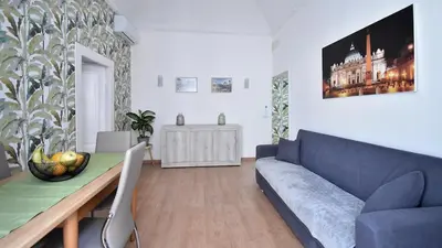 a living room with a blue couch and a table at Due passi dal cupolone - appartamento al centro in Rome