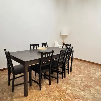 a dining room table with black chairs and a table and a lamp at Angelico Home in Rome