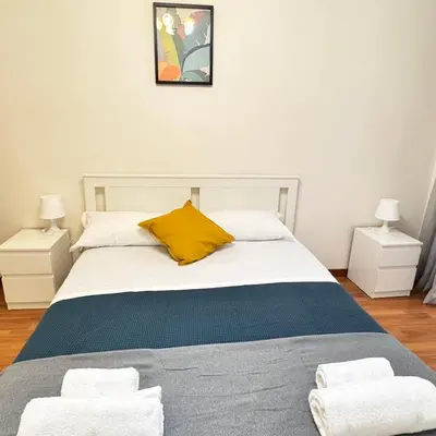 a bedroom with a bed with a yellow pillow and two night stands at Angelico Home in Rome