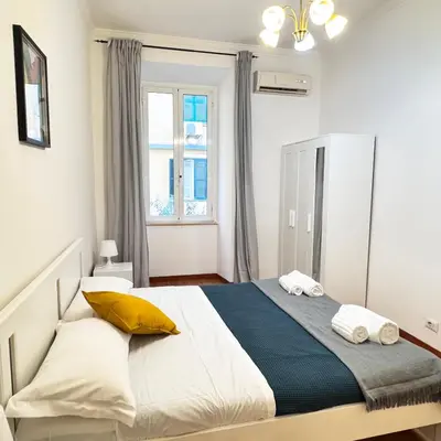 a bedroom with a large bed with yellow pillows at Angelico Home in Rome