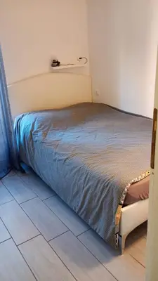 a bed sitting in a room with a tiled floor at Ponte Milvio Loft in Rome