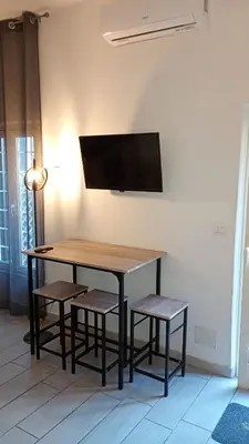 a table with two chairs and a television on a wall at Ponte Milvio Loft in Rome