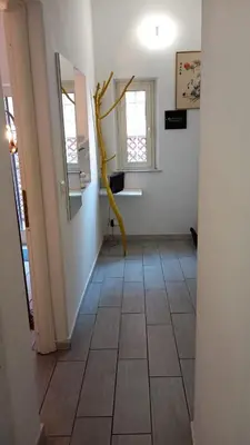 a hallway with a yellow branch on the wall and two windows at Ponte Milvio Loft in Rome