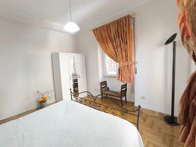 a bedroom with a bed and a window and a chair at Alloggio Turistico Giotta in Rome