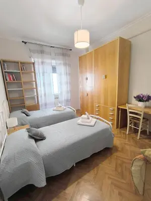 a bedroom with two beds and a table and a desk at Alloggio Turistico Giotta in Rome