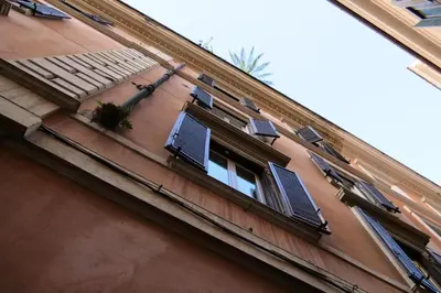 a building with a window with shutters on it at Dimora Vantaggio in Rome