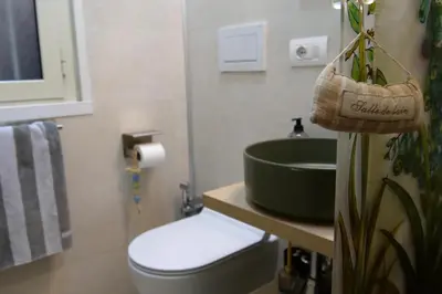 a bathroom with a green sink and a toilet at Dimora Vantaggio in Rome