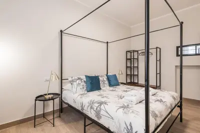a bedroom with a black canopy bed with blue pillows at C1 Top Class Apartments, 2 camere delux, max 6 persone distante 15 minuti a piedi da Fontana di Trevi in Rome