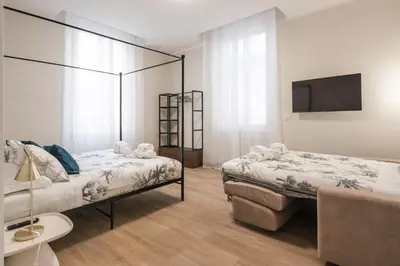 a bedroom with two beds and a flat screen tv at C1 Top Class Apartments, 2 camere delux, max 6 persone distante 15 minuti a piedi da Fontana di Trevi in Rome