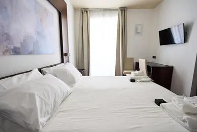 a white bed in a room with a window at Gemini Rooms in Rome