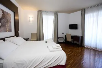 a hotel room with a large bed and a television at Gemini Rooms in Rome